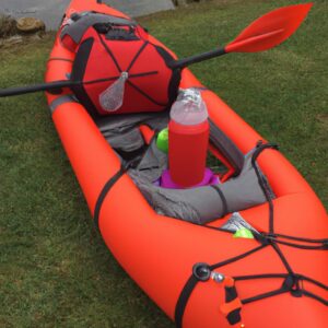 a red kayak camping gear with a spear