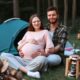 a pregnant woman camping with a man