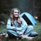 a lady in pajamas sitting at a campsite