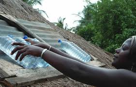 A lady with bottles of water is going through the solar water disinfection process for water purification