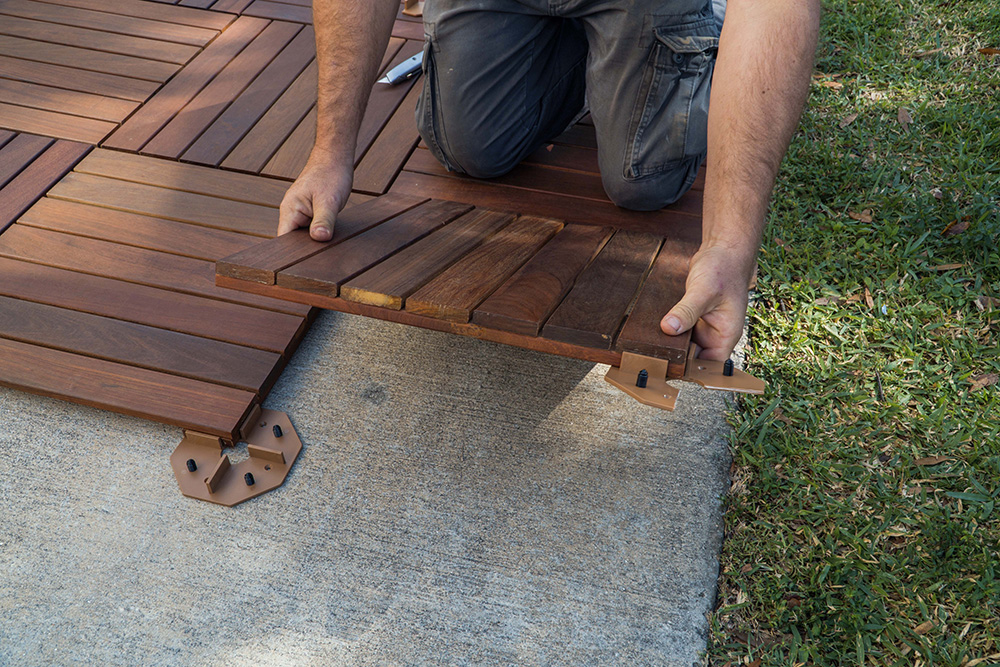 Best ways to cover a concrete patio by installing a wooden deck for a natural outdoor feel
